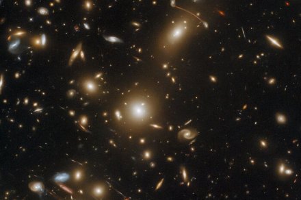 This galaxy cluster is so massive it warps space-time and bends light